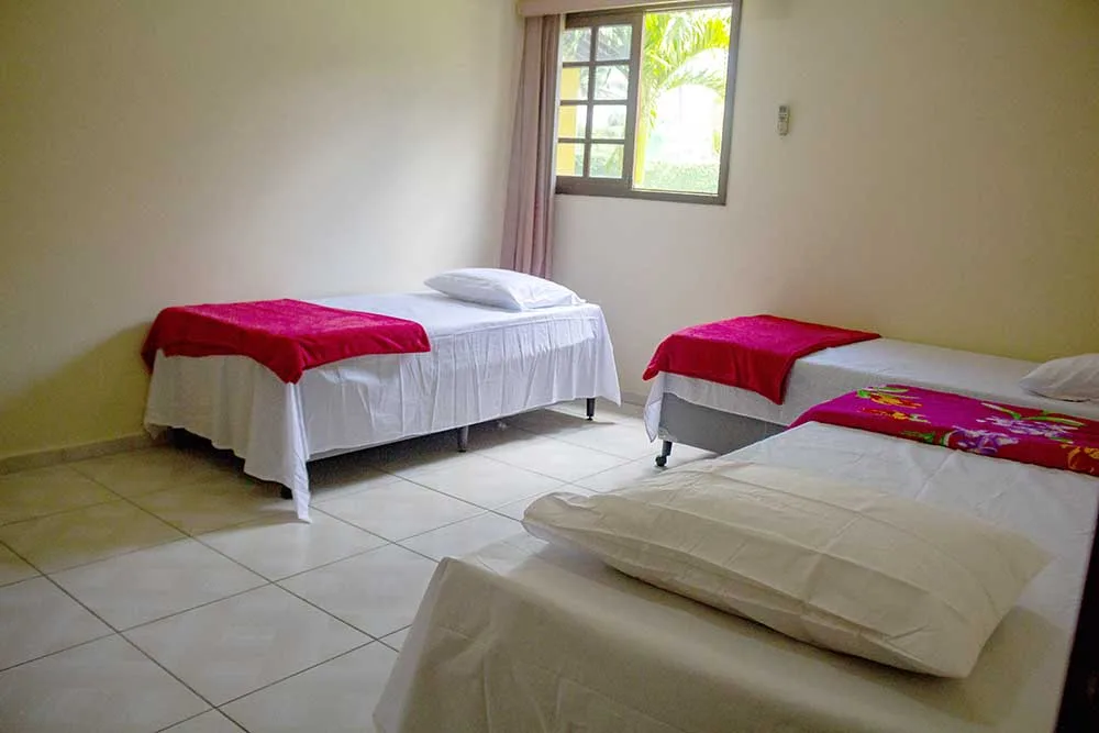 Quarto com duas camas de solteiro e janela